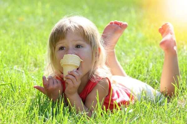 公園の自然の中でアイスクリームを食べる幸せな子供 — ストック写真