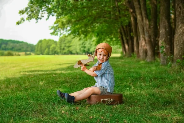飞机旁边的小男孩在公园里玩大自然的游戏 在度假的男孩飞行员 — 图库照片