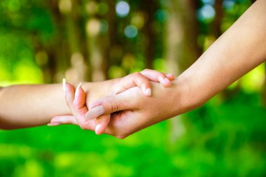 Mutlu aile ve çocuk parkta el ele tutuşuyor.