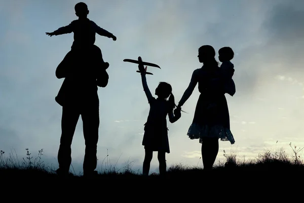 silhouette of a happy family with children on natur