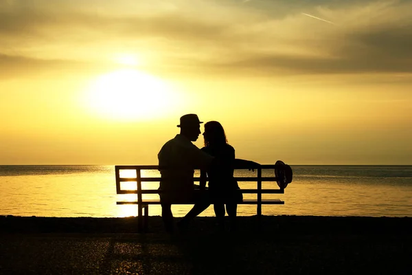 在日落时分 一对快乐的恋人在海滨长椅上的肖像 — 图库照片