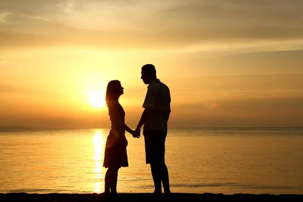 海岸の日没時の幸せな恋人のシルエット — ストック写真