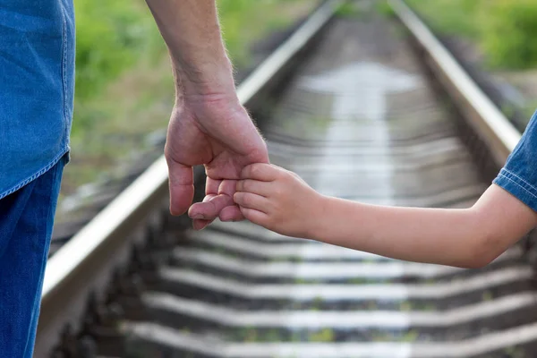 父母牵着小孩的手与铁路和方向 — 图库照片