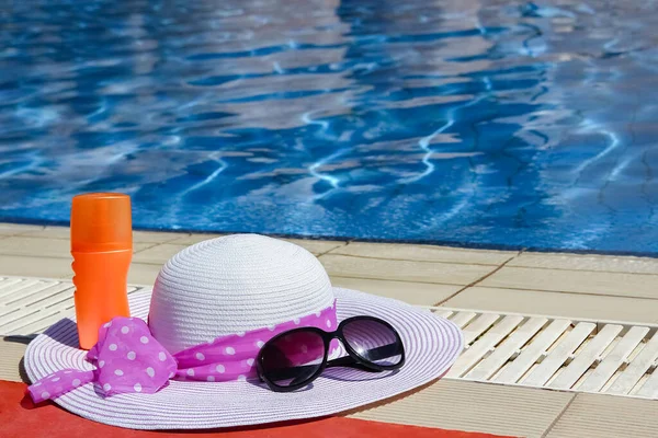 プールの近くでクリームとグラスを背景にした美しい帽子 — ストック写真