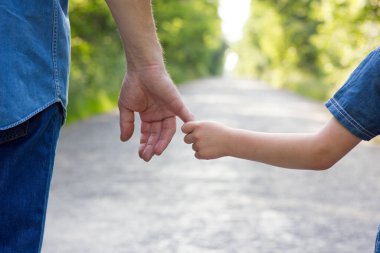 Aile, yol kavramında küçük bir çocuğun elini tutar.
