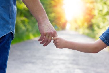 Aile, yol kavramında küçük bir çocuğun elini tutar.
