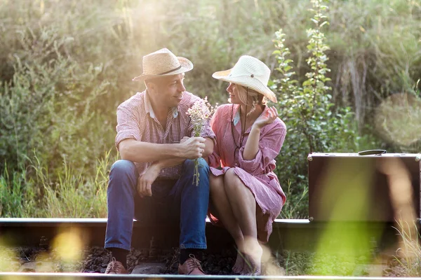 一对恋爱中的牛仔夫妇 带着手提箱靠近铁路 — 图库照片