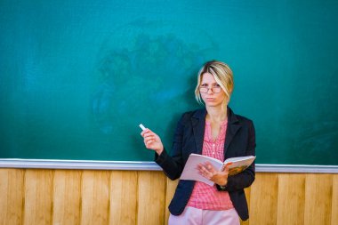 Sınıftaki tahtadaki mutlu öğretmen sınıfa geri döndü.