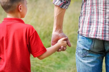 Park aile kavramında mutlu çocuk ve ebeveynin elleri