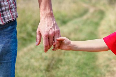 Park aile kavramında mutlu çocuk ve ebeveynin elleri