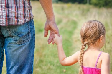 Park aile kavramında mutlu çocuk ve ebeveynin elleri