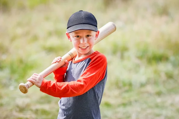 Happy child with baseball bat on nature concept in park