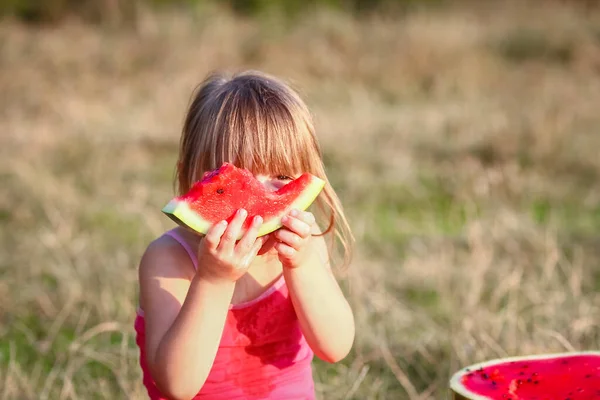 公園で自然の中でスイカの概念を食べる幸せな子供 — ストック写真