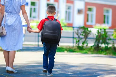 Mutlu anne okula dönerken çocuğu okula götürüyor.