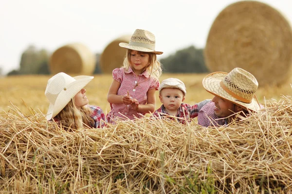 Family on haystacks in cowboy hats — Stock Photo, Image