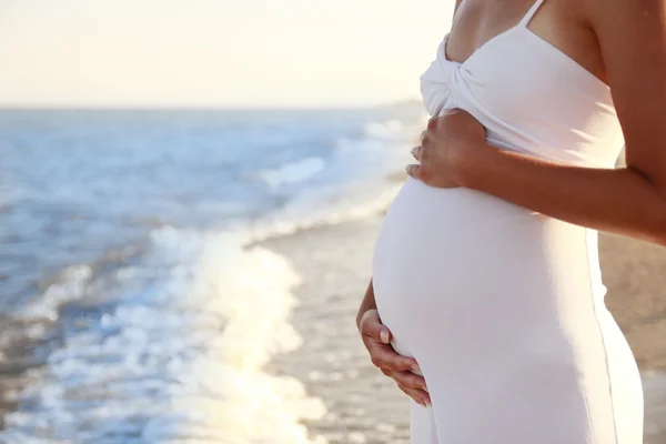 Zwangere vrouw op het strand — Stockfoto