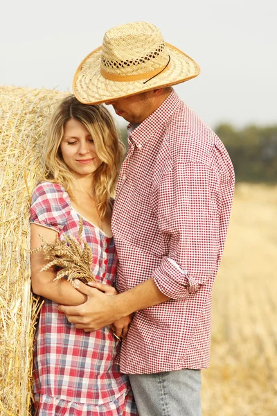 Couple embracing near haystacks — Stock Photo, Image