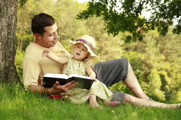 Отец с маленькой дочерью читает — стоковое фото