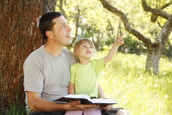 Padre con hija pequeña leyendo —  Fotos de Stock