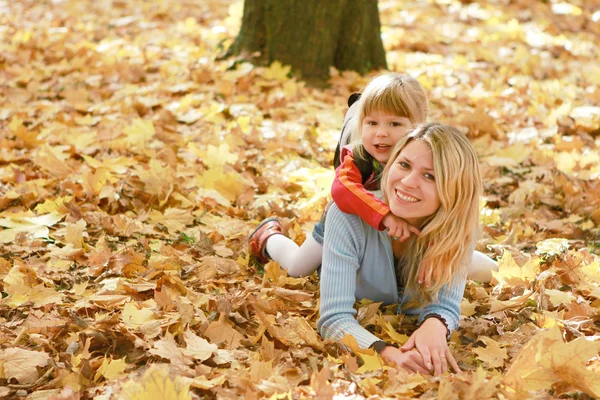Mama och lilla dotter i bladverk — Stockfoto