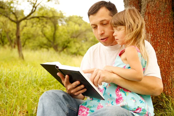 Padre con hija pequeña leyendo — Foto de Stock