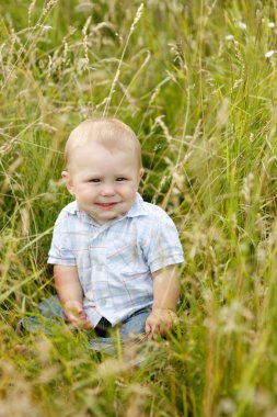çimlerde oturan çocuk