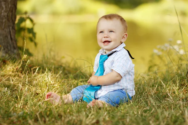 Pojken sitter på gräset — Stockfoto