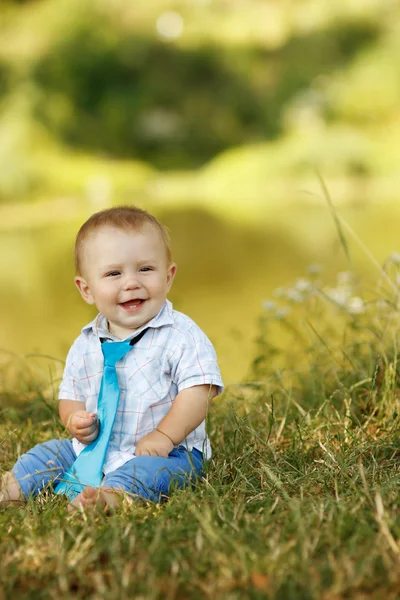 Pojken sitter på gräset — Stockfoto