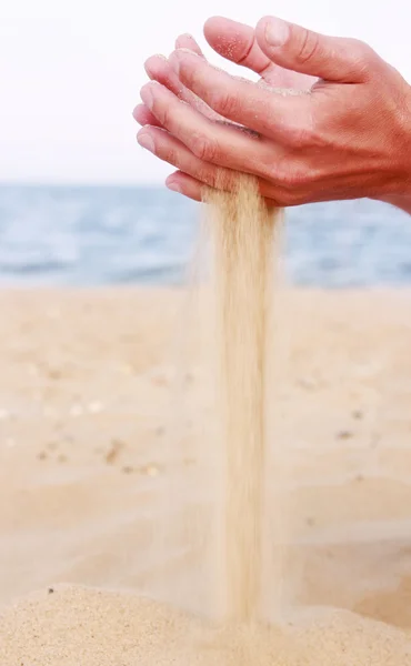 Mãos masculinas derramando areia — Fotografia de Stock