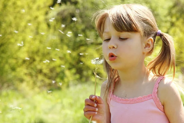 Dziewczyna dmuchanie na dandelion — Zdjęcie stockowe