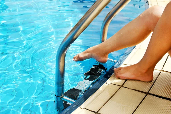 Vrouwelijke benen in de buurt van zwembad — Stockfoto