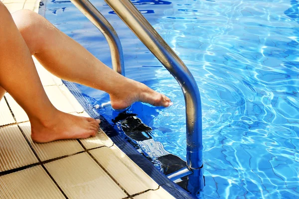 Vrouwelijke benen in de buurt van zwembad — Stockfoto