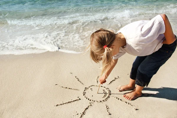 Girl draws on sand — Stock Photo, Image