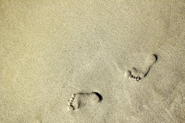 Footprints on the sand at the beach clipart