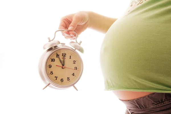 Pregnant woman with an alarm clock — Stock Photo, Image