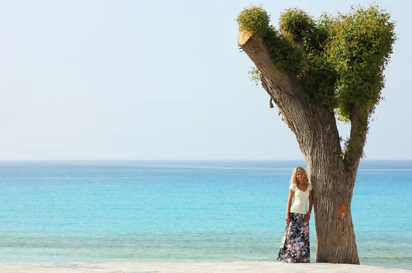 Mulher de pé perto da árvore — Fotografia de Stock