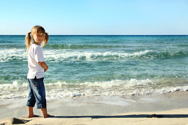 ребенок играет на берегу
