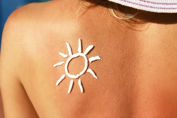 Crema solar en la espalda femenina — Foto de Stock