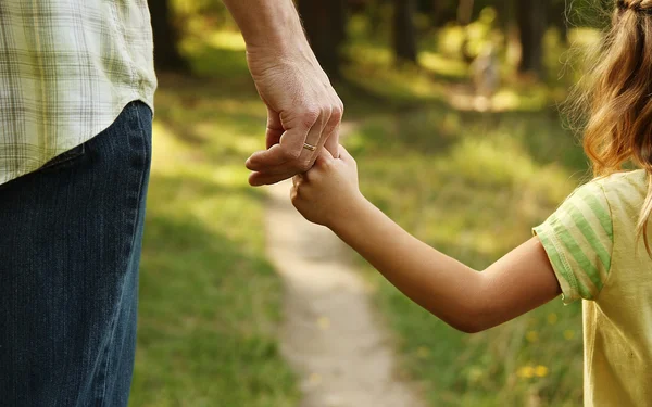 Bovenliggende houdt de hand van kind — Stockfoto