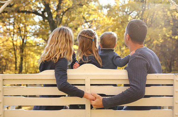 Οικογένεια κάθεται σε παγκάκι στο πάρκο — Φωτογραφία Αρχείου