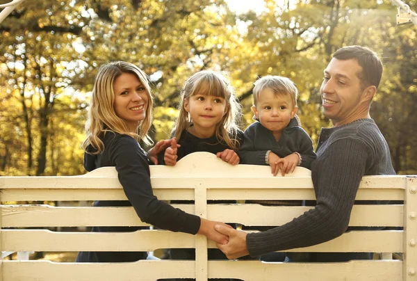 Rodina sedí na lavičce v parku — Stock fotografie