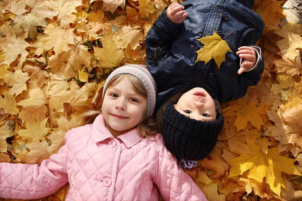 Çocuk sonbahar yaprakları üzerinde yalan — Stok fotoğraf