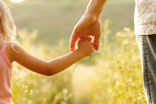 Родитель держит за руку ребенка — стоковое фото