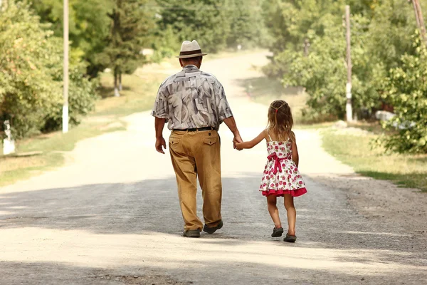 Farfar med barnbarn gå på väg — Stockfoto