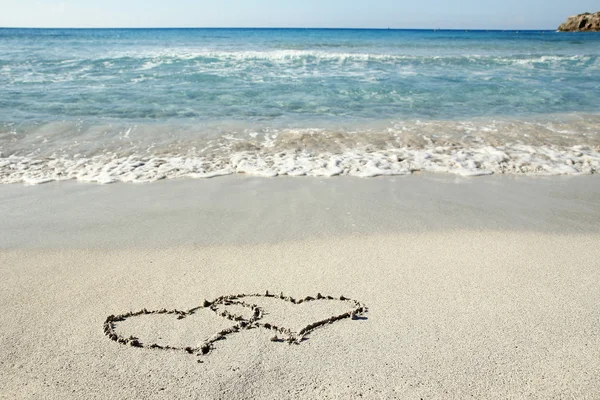 Corazones en la arena en la playa — Foto de Stock