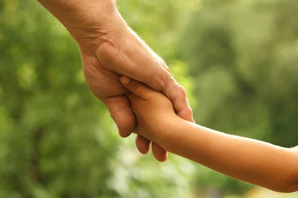 Bovenliggende houdt de hand van kind — Stockfoto