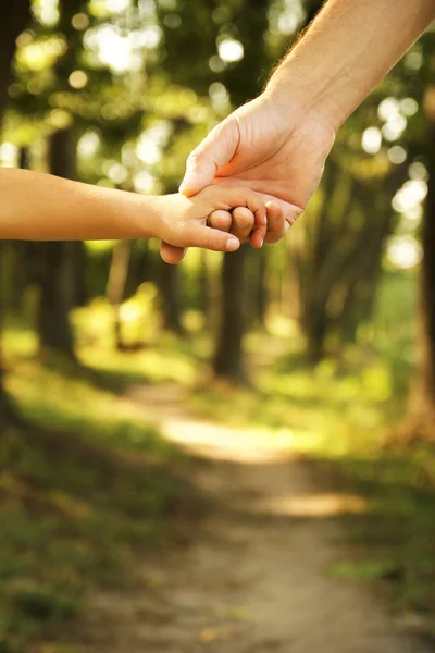 Bovenliggende houdt de hand van kind — Stockfoto