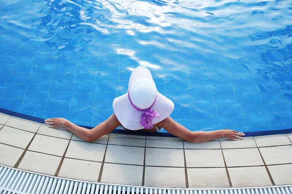 Дівчина з капелюхом в басейні — стокове фото