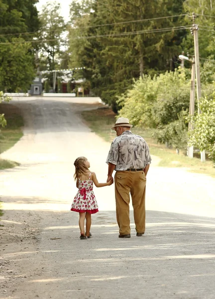 Grandfather with the granddaughter   on road — Stock Photo, Image