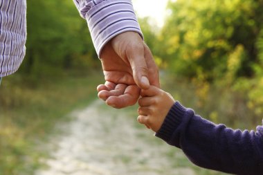 Parent holds hand of child clipart